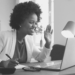 A person sitting at a desk with a computer and a lamp