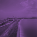 A body of water, a stretch of land and some wind turbines with a purple overlay